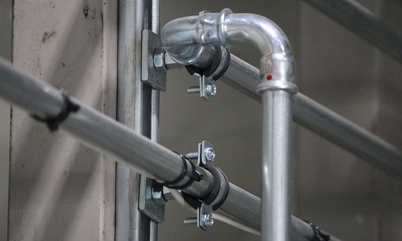 Professional installation team fitting garage workshop equipment and vehicle lift