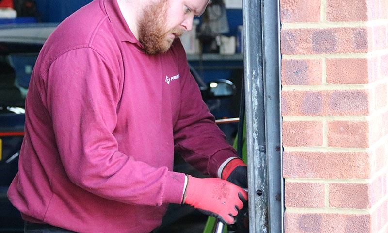 Engineer carrying out scheduled maintenance on an industrial roller shutter door