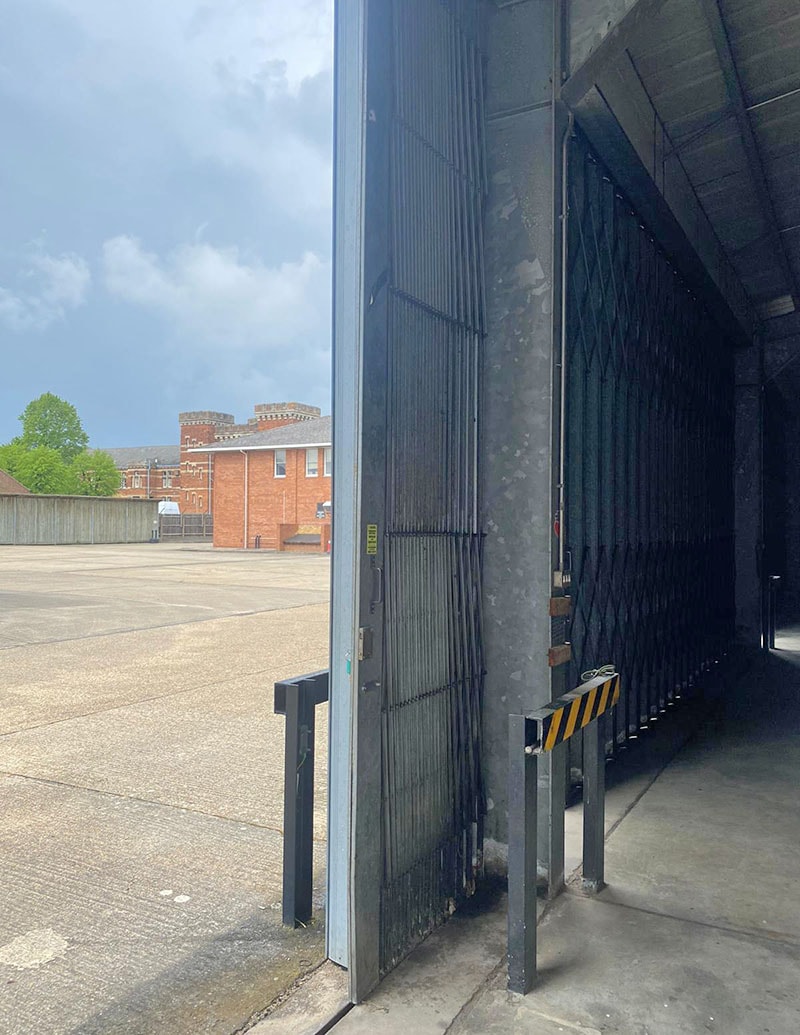 Sliding folding door open on an industrial building courtyard