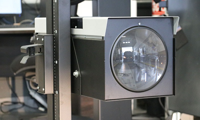 Headlamp beam alignment tester on wheels in a workshop