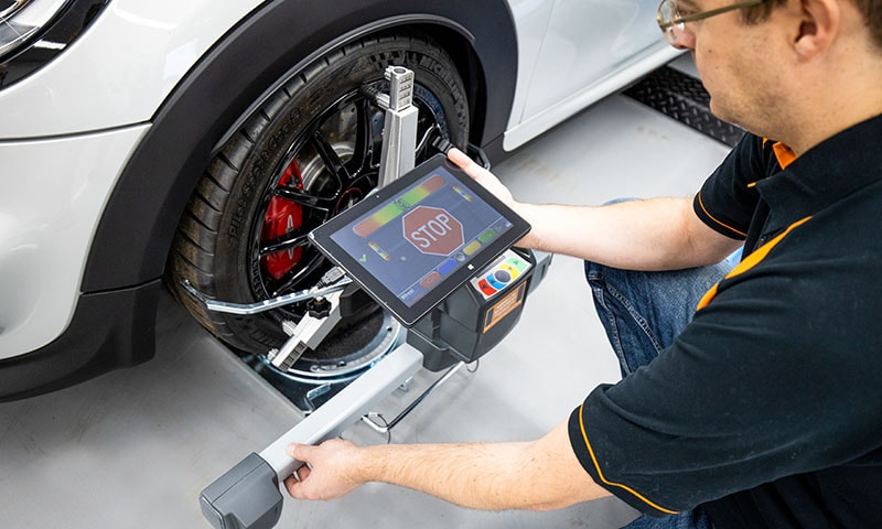Wheel alignment equipment in use in a professional garage workshop