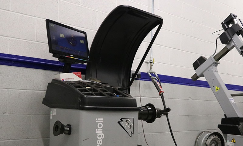Computerised wheel balancer machine in professional workshop